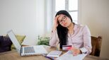 Image of young women at desk with credit card and calculator