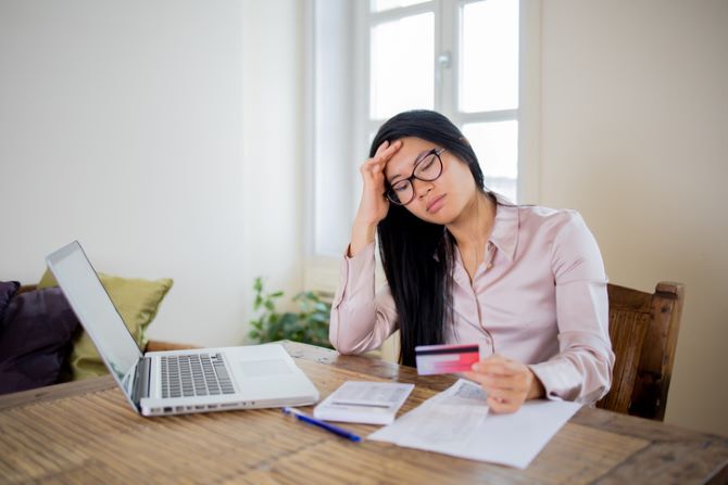 Image of young women at desk with credit card and calculator