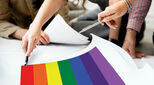 Pride flag on drawing board with people making plans