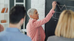Older woman writing on board