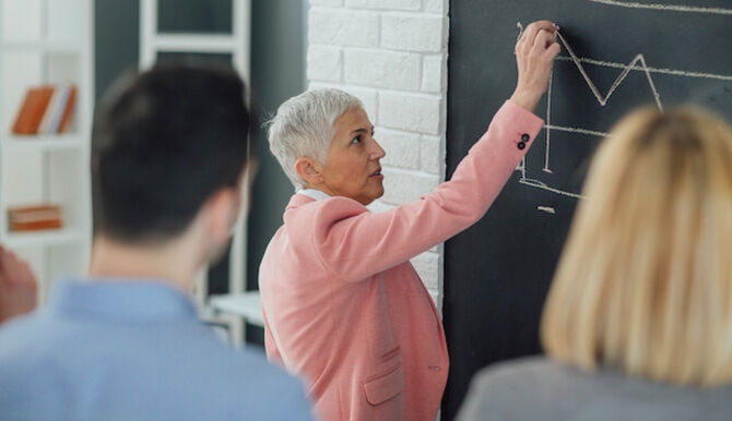 Older woman writing on board