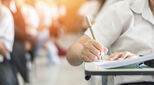 Exam with school student having a educational test, thinking hard, writing answer in classroom for university education admission and world literacy day concept