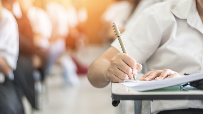 Exam with school student having a educational test, thinking hard, writing answer in classroom for university education admission and world literacy day concept