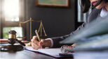 Picture of female judge with gavel and scales of justice imbalanced in the background