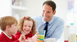 Father and two children eating breakfast