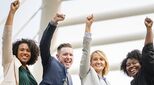 Team of happy people punching the air in joy