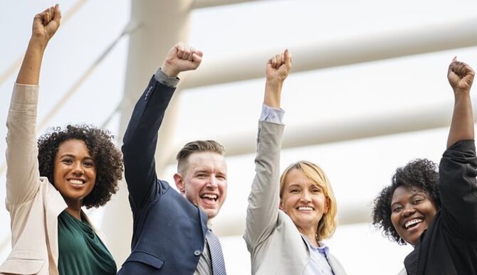 Team of happy people punching the air in joy