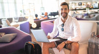 Man using laptop in hotel lobby