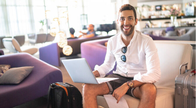 Man using laptop in hotel lobby