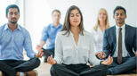 Colleagues meditating in the office