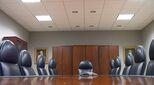 Image of empty board room with images of men in paintings on wall