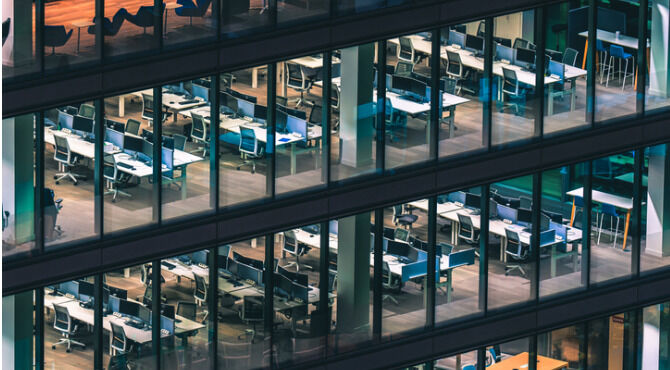 Modern glass building high above Brussels city skyline at night with illuminated offices