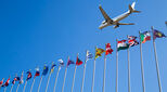 Aeroplane flying over flags from many nations