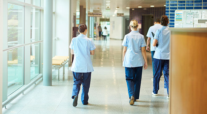 NHS staff walking along corridor