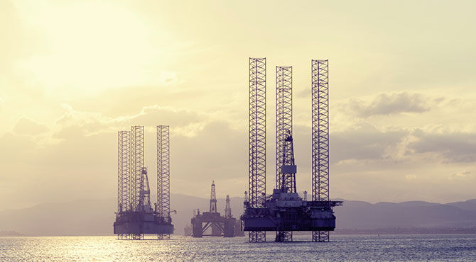 Three North Sea oil rigs at sunset