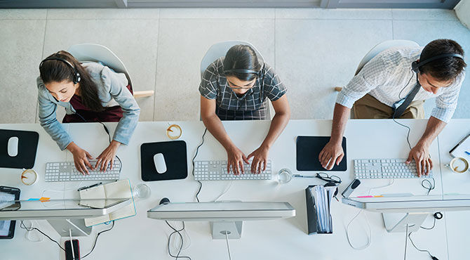 Three service sector workers, working on Macs