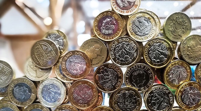 Pound coins in a charity box