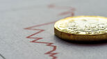 Pound coin on a background showing financial downturn