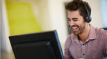 Happy professional man on headset and laptop