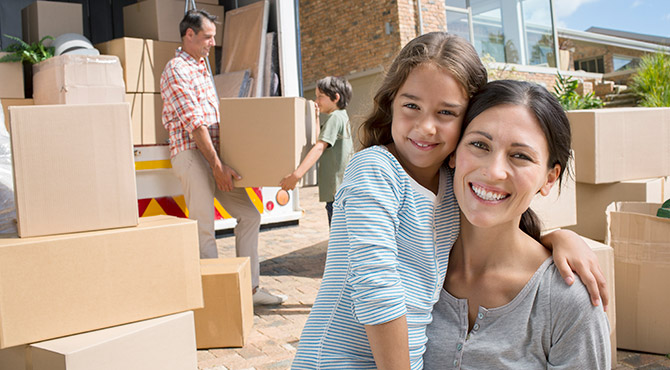 Family in the process of moving, with van and boxes