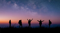 ilhouette group of young traveler and backpacker watched the star and milky way on top of the mountain with twilight sky. He enjoyed traveling and was successful when he reached the summit.