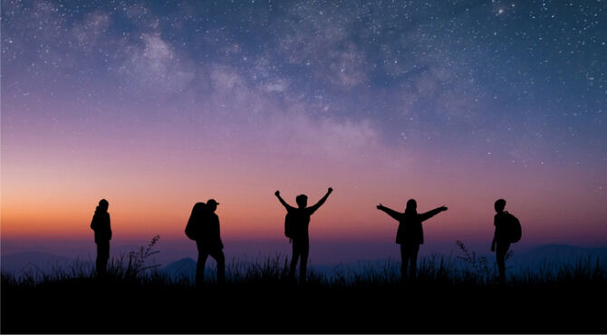 ilhouette group of young traveler and backpacker watched the star and milky way on top of the mountain with twilight sky. He enjoyed traveling and was successful when he reached the summit.