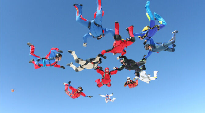 Team of airborne skydivers in formation