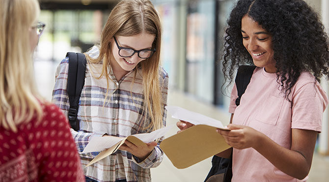 Three female students look happy about exam results