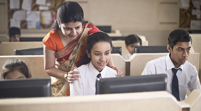 Computer teacher assisting a student