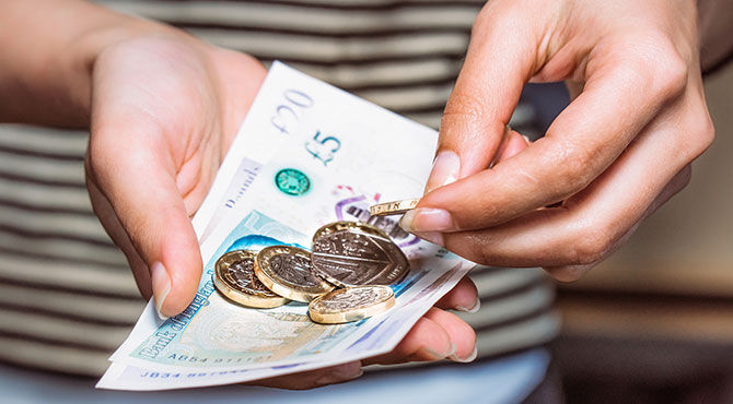 Shopper holding UK currency