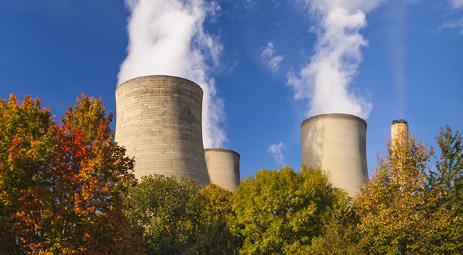 Image of a UK nuclear plant with trees with autumn leaves in the foreground