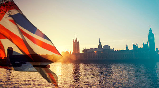 Union Jack flag waving in front of the UK Houses of Parliament in London