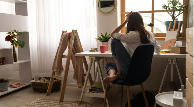 Woman at desk with head in hands