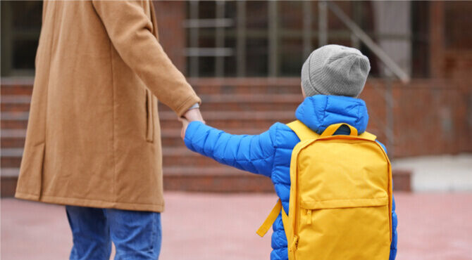Image of small boy and parent at school drop off