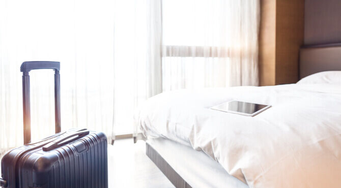 Image of hotel room with suitcase and tablet