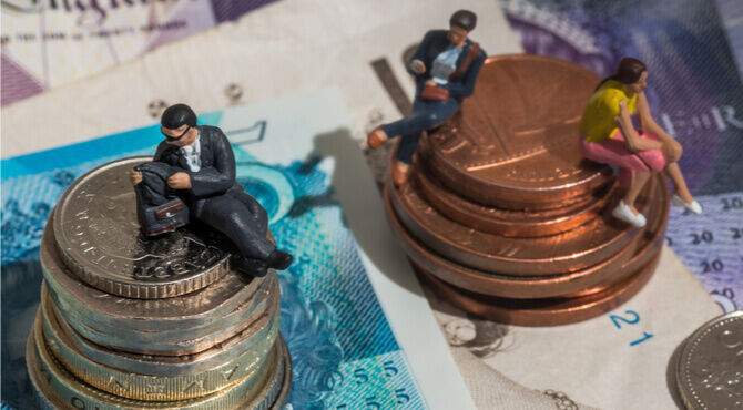 Image of UK currency and small figures sitting on piles of coins