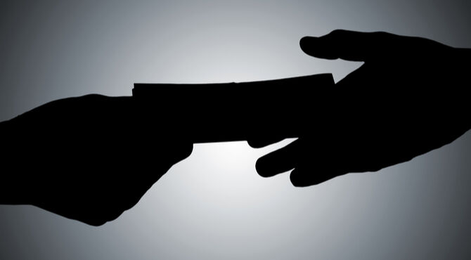 Silhouetted handshake and cash