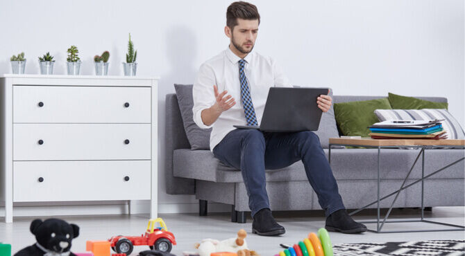 Image of stressed parent working at home amid chaos of toys