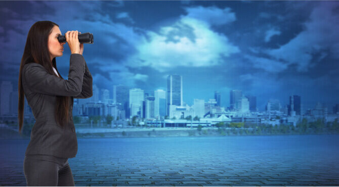 Business person surveying horizon with binoculars