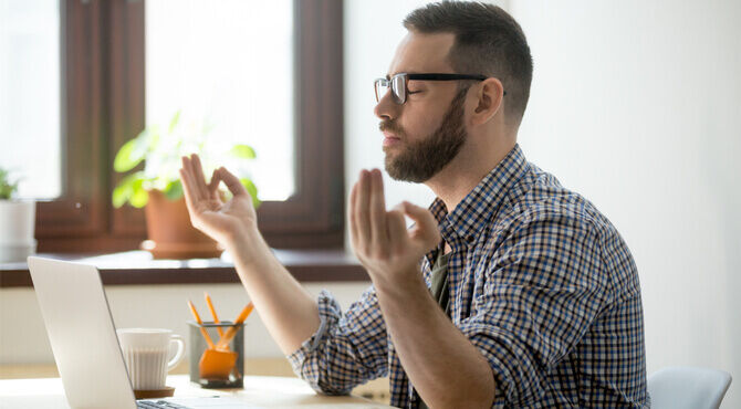 Image of man at desk meditating