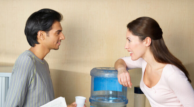 Image of two colleagues chatting at water cooler