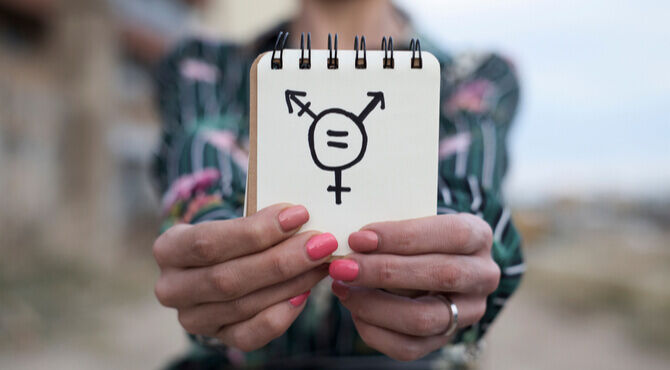 Image of person holding transgender symbol