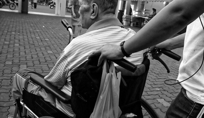 Image of man pushing wheelchair