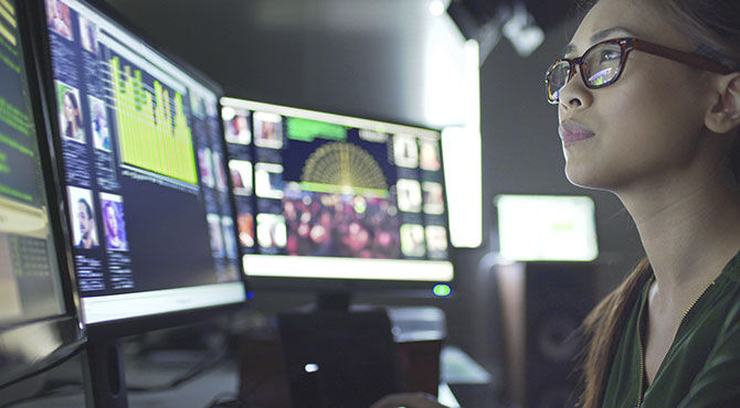 Woman working on two computer screens