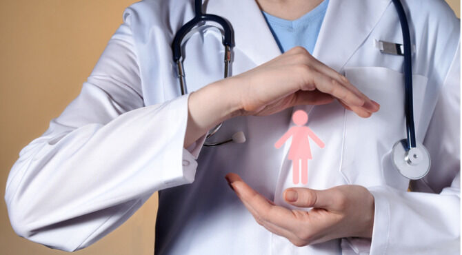 A woman doctor holds a woman's pictograph in her hands. Female doctor with a stethoscope gesticulating on a beige background.