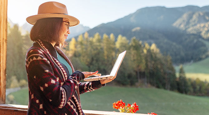 Woman with laptop working in an outdoor setting