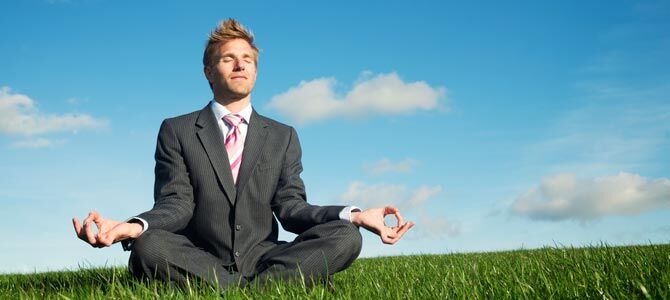 Young man in business suit practices yoga