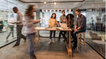 Creative people standing in the office and working together on computer. Blurred motion.