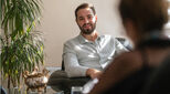 A young man is getting advice from a female professional mental health doctor at her office.